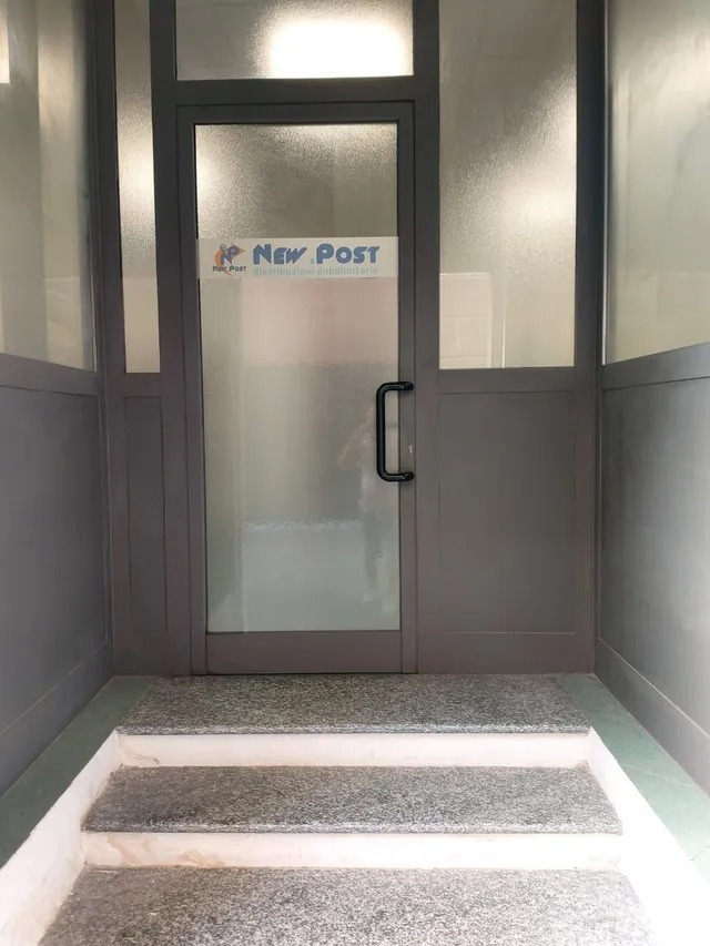 Ingresso degli uffici New Post con porta a vetri e logo